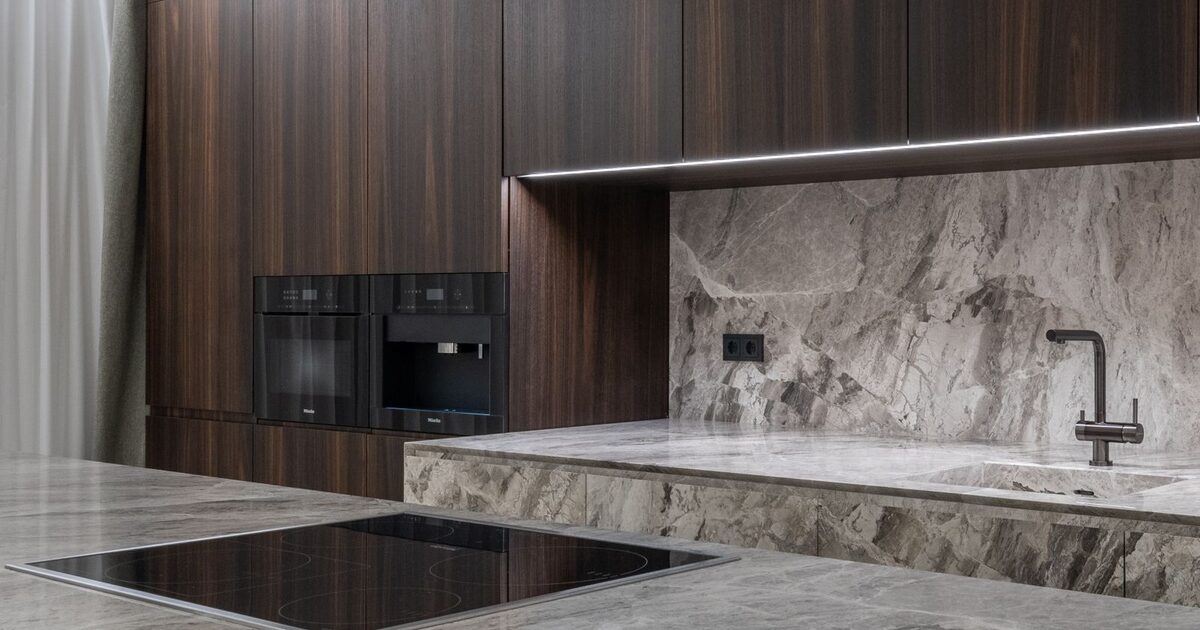 Modern kitchen with a cooktop, extractor hood and marble countertops