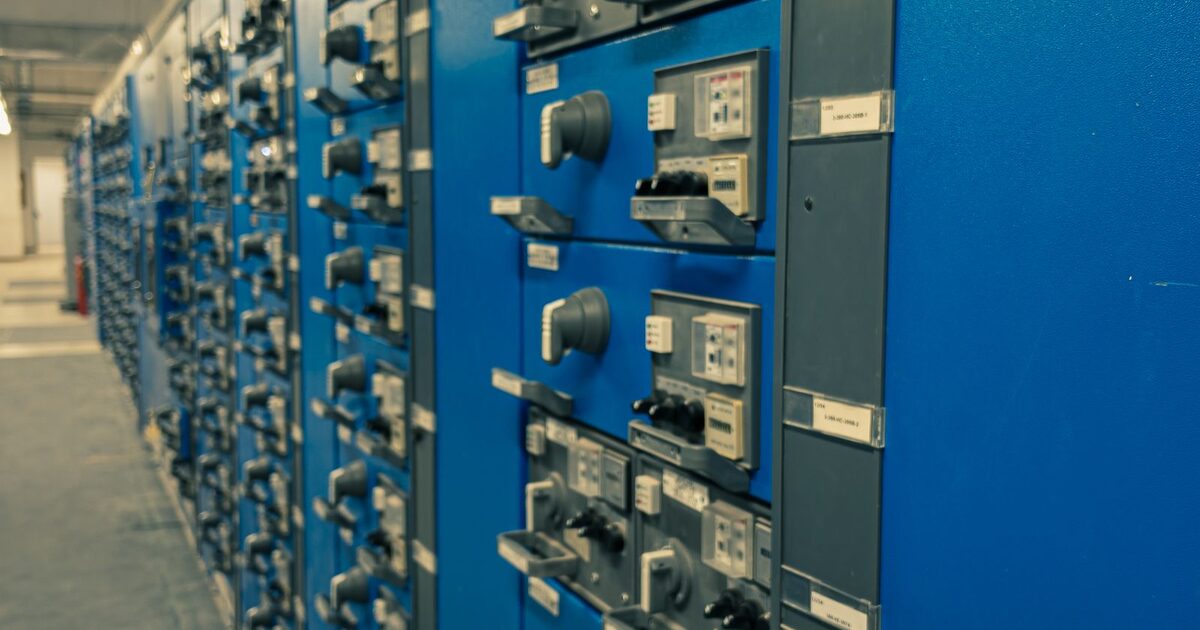 Rows of blue electrical control cabinets in an industrial equipment room