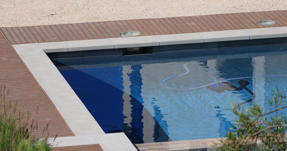 Outdoor swimming pool with clear water beside timber decking
