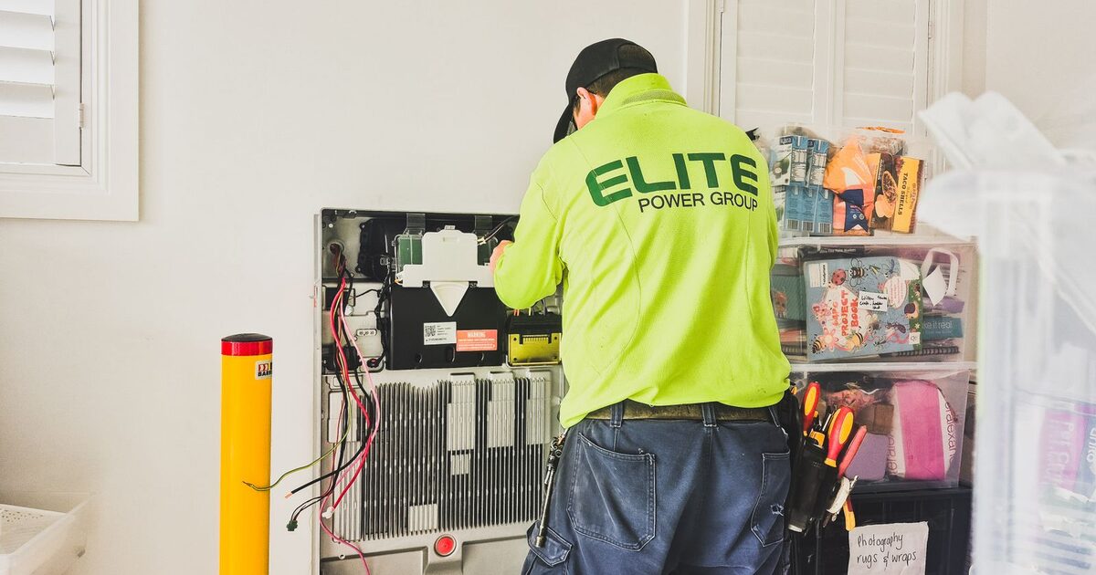 Technician checking equipment during an indoor home battery installation