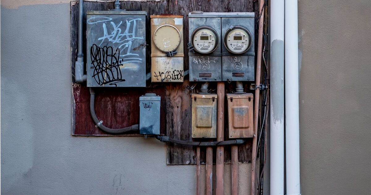Electrical enclosures and supply cables mounted along a wall